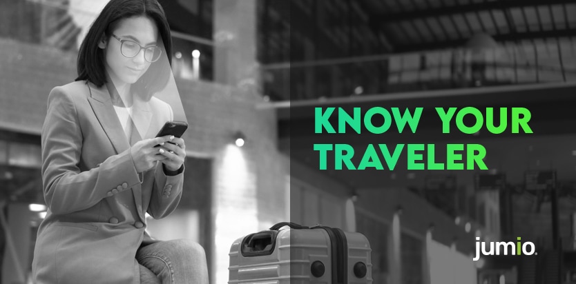 image of women sitting down with her legs crossed looking at her smart device. The women is wearing glasses with a suitcase next to her. Text on image reads: Know Your Traveler.