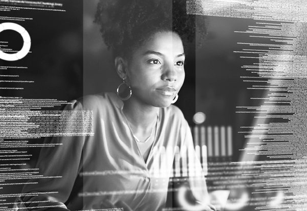 image of woman with her hair up and wearing earrings sitting at a desk looking at a computer.