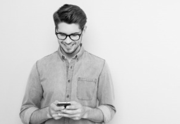image of male wearing glasses holding smart phone.