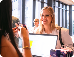 image of woman smiling to front desk lady. Woman is checking in.