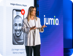 image of woman presenting. Jumio slideshow is being shown in the background.