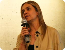 image of woman holding a microphone speaking to audience