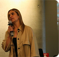image of woman holding a microphone speaking to audience