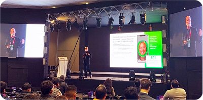 image of speaker on stage presenting Jumio slide show.