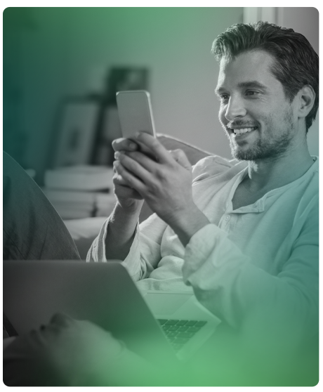 image of male smiling at smart phone in hand.