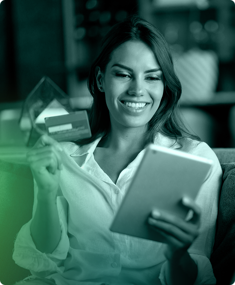 woman holding credit card in one hand and tablet in the other. Woman is smiling.