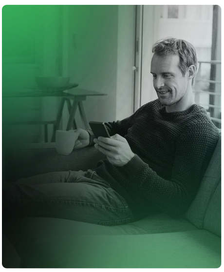 image of guy sitting on couch with his phone in his hand.