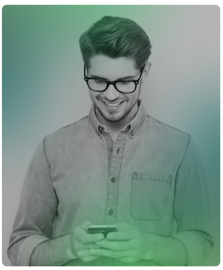 man wearing glasses and smiling. He is looking down at his smart phone device