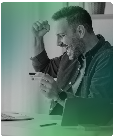 image of man holding up his fist smiling with his credit card in the other hand.