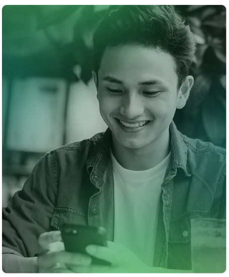 Image of young male smiling at his phone sitting.
