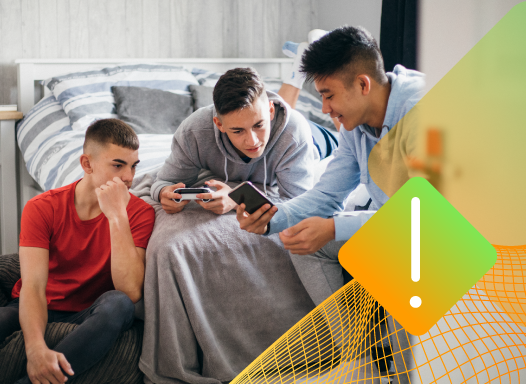 Three teenage boys gathered around a smartphone, with a caution warning icon overlaid, illustrating the risk of underage access to online sports betting platforms.