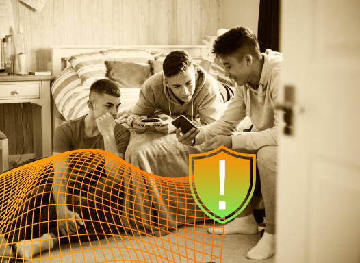 Sepia-toned photo of three teenage boys looking at a phone in a bedroom, with a warning shield icon overlay